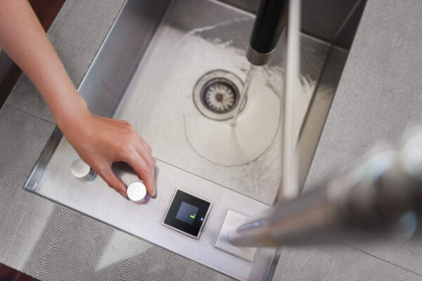 Woman's hand turning off the tap in the kitchen