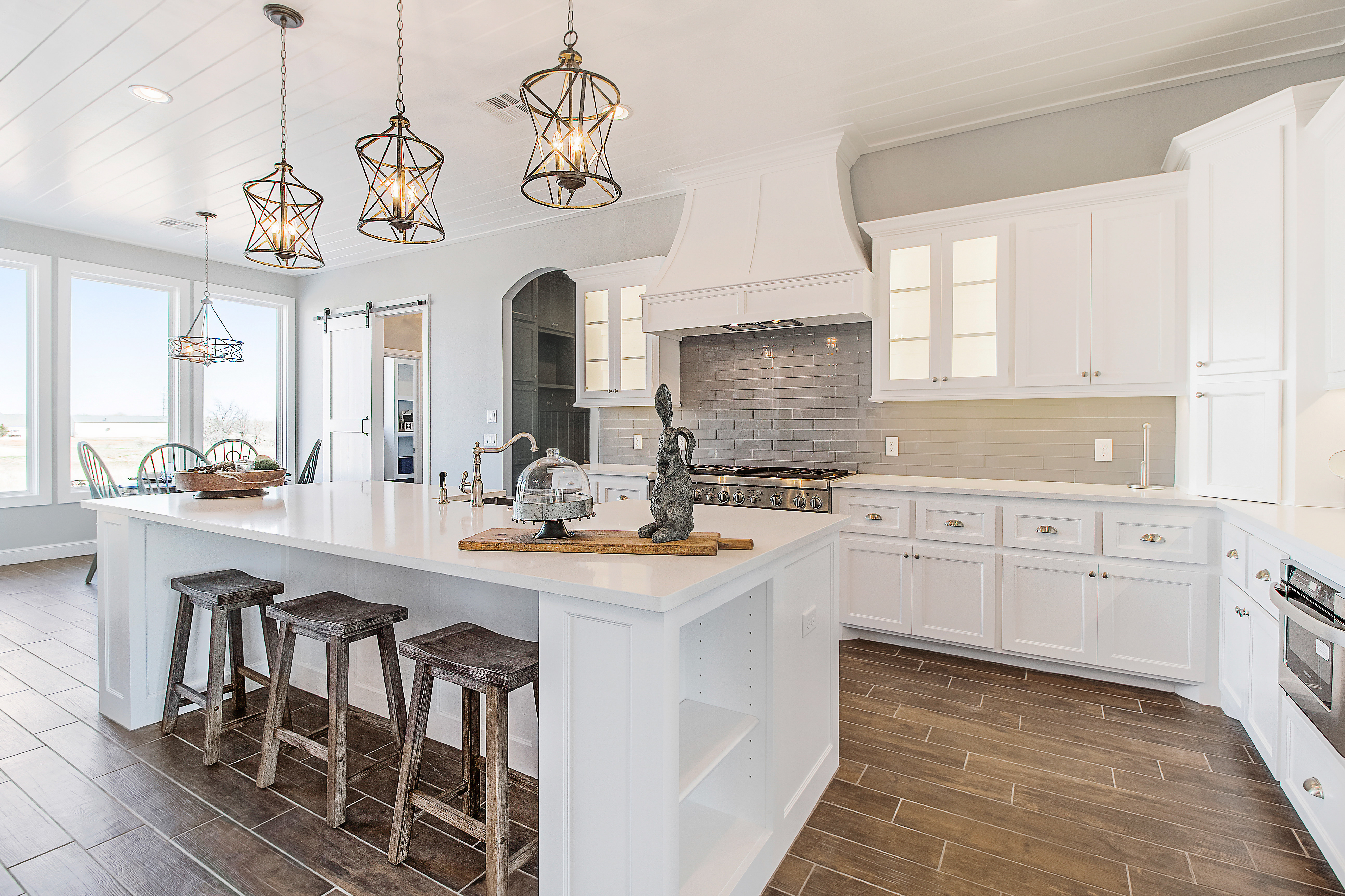 Upscale kitchen interior, farmhouse stools and rustic light fixtures