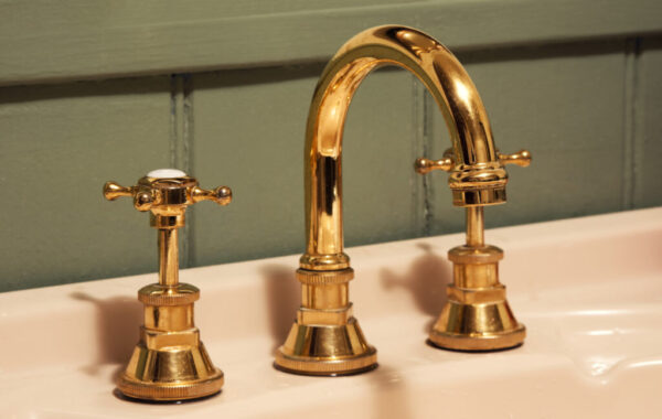 Close-up of golden faucet and sink faucet