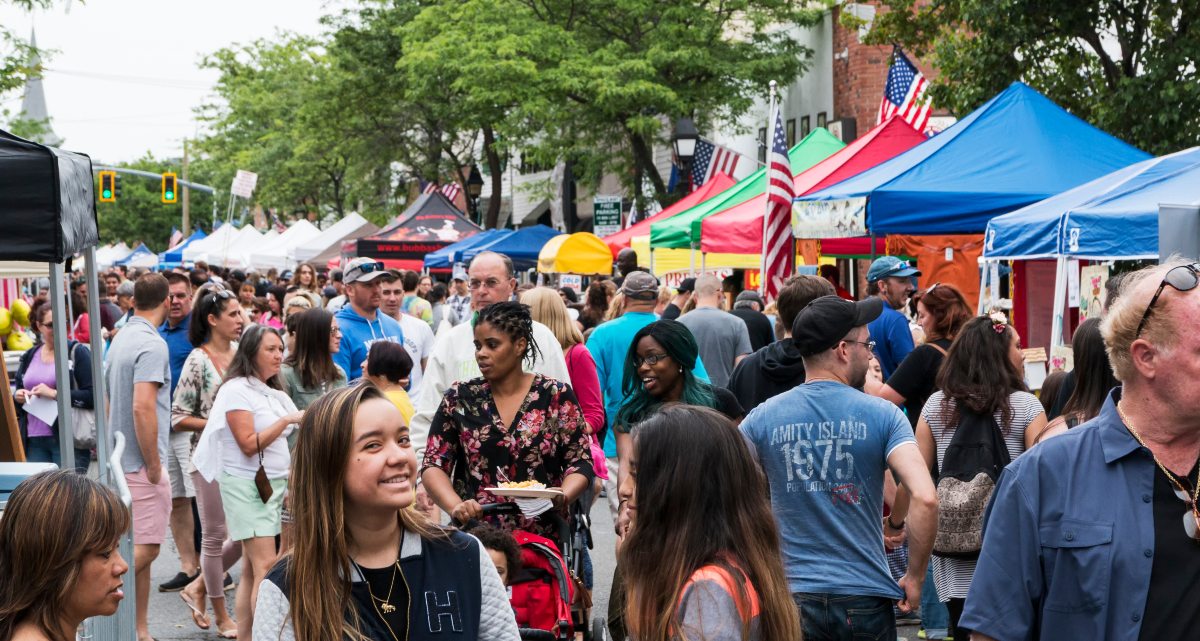 People fill the streets at a street fair.