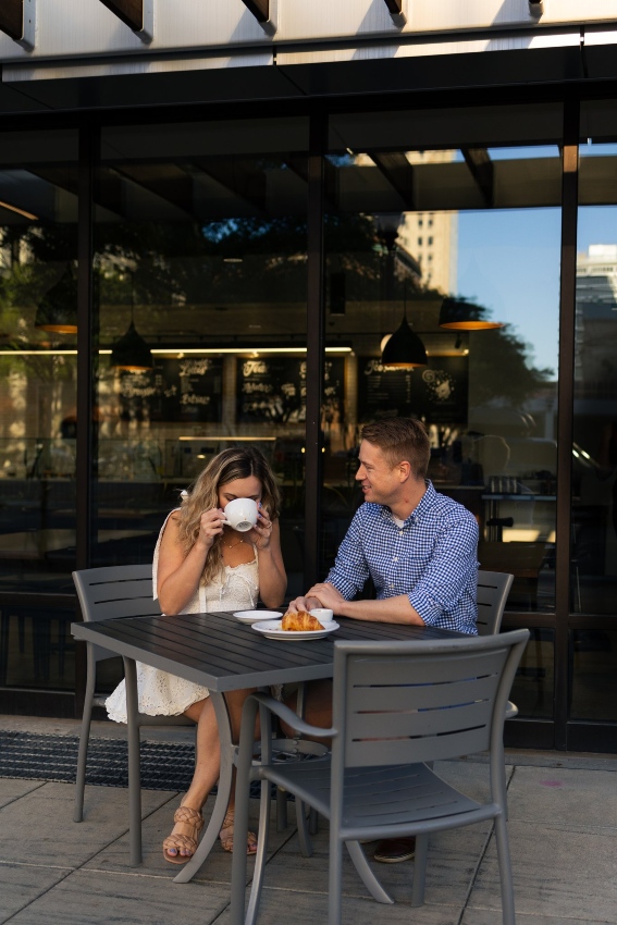 A couple sits at a local Fort Wayne, IN coffee shop sipping drinks from white ceramic cups as captured by Kathryn Schneider Photography.