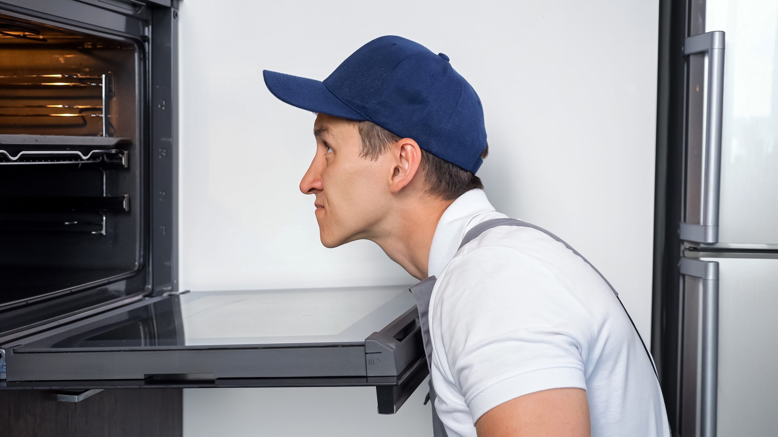 repairman checking appliances in the kitchen