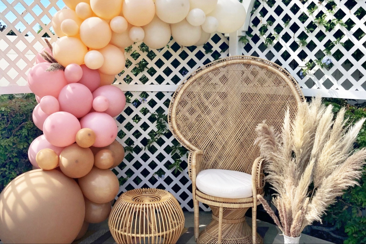 Rainbow ballon garland and boho chair great for a nesting and baby shower party 