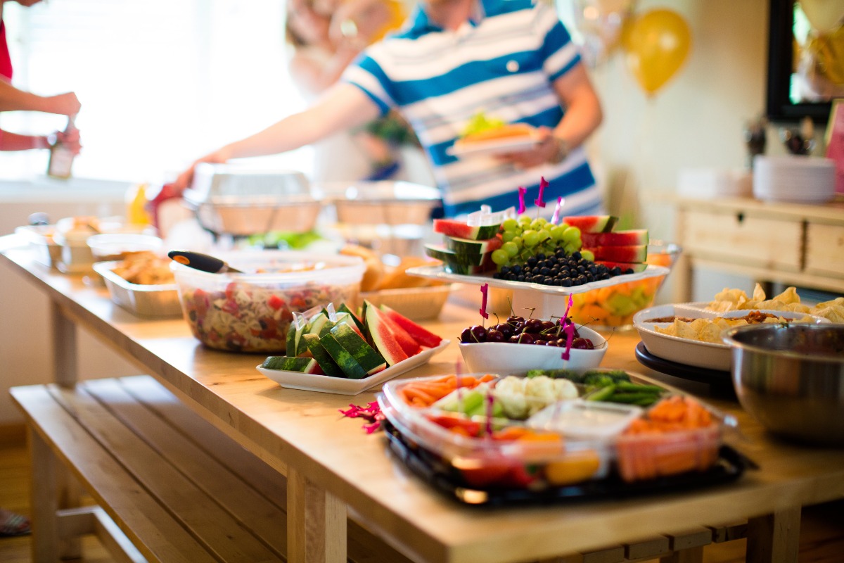 Une propagation des aliments d'été se trouve sur une table. Il est facile de saisir et de garder un espace disponible pour organiser une fête d'été dans un appartement. 